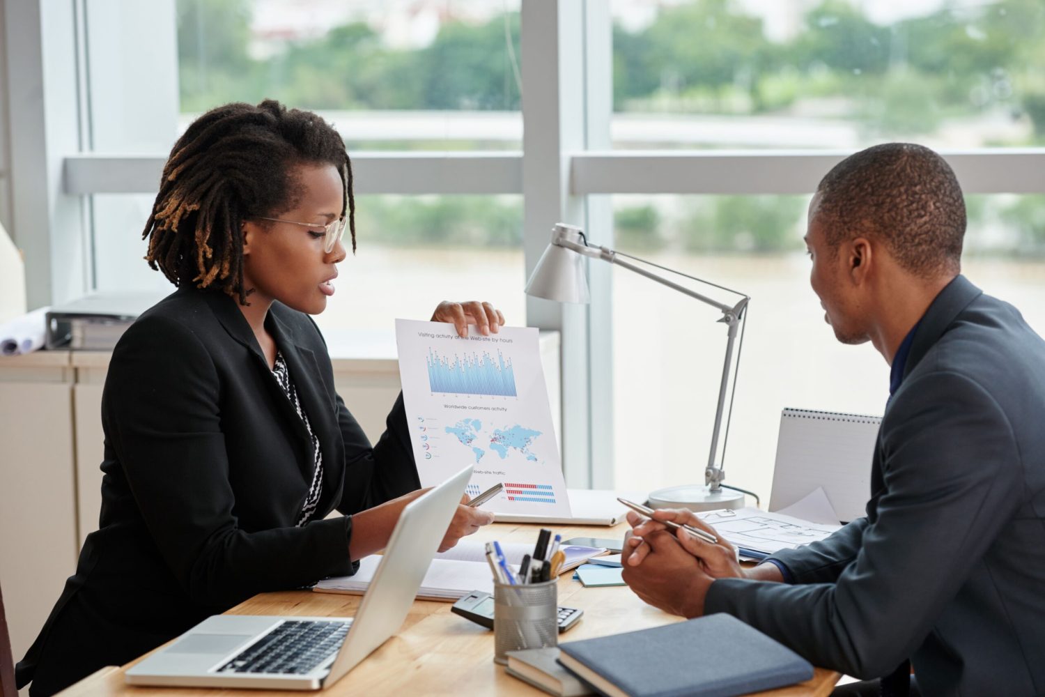 side-view-businesswoman-showing-analytical-charts-her-male-coworker (1)